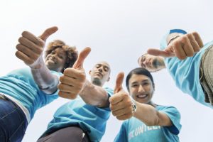 A group of people showing their thumbs up because they know the proper advice on hiring movers for the first time.