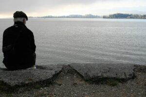 Senior sitting by the lake