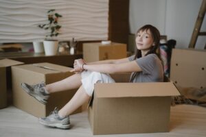 Woman sitting in a cardboard box