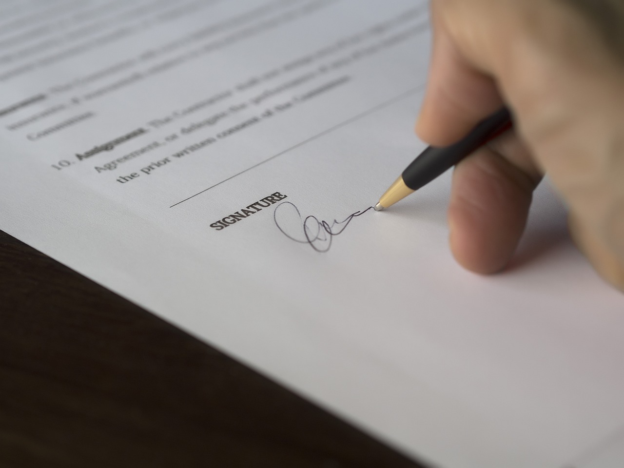 A person signing a contract after hiring professional movers.