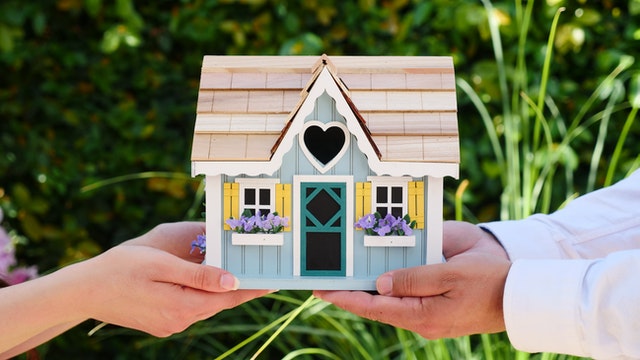 A couple holding a small model house.