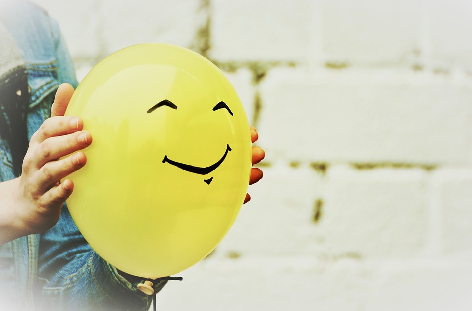 A yelloww ballon with a smiley face.